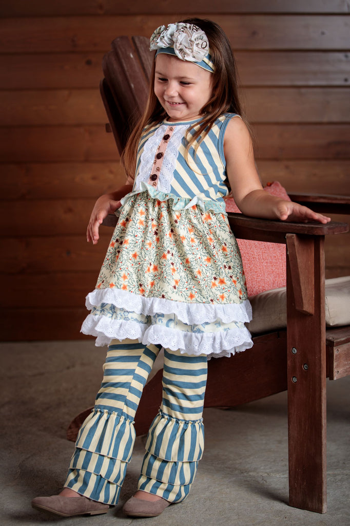 Precious delicate flowers , buttons and ruffles make up this 2 piece outfit. Soft colors of blue and lace detail this dress and pants. Sizes 2T-7T.